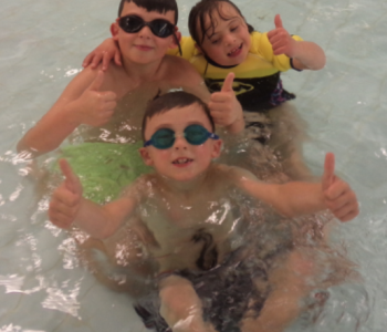 Children Swimming with thumbs up